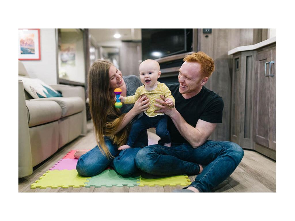 Alyssa and Heath holding up Ellie in the living room of their Forza