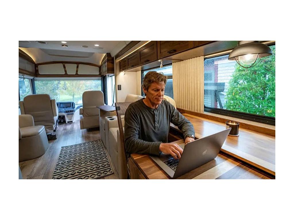 Adult person sitting at desk in Journey working on laptop