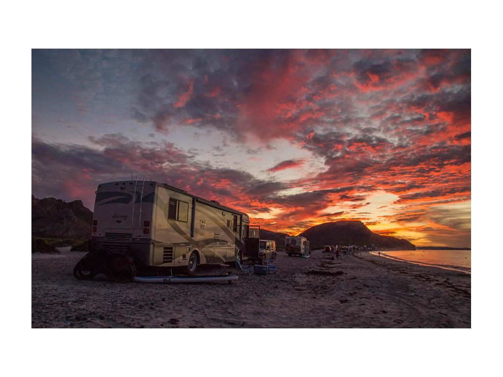 Journey dry camping on the beach with pink sunset in background