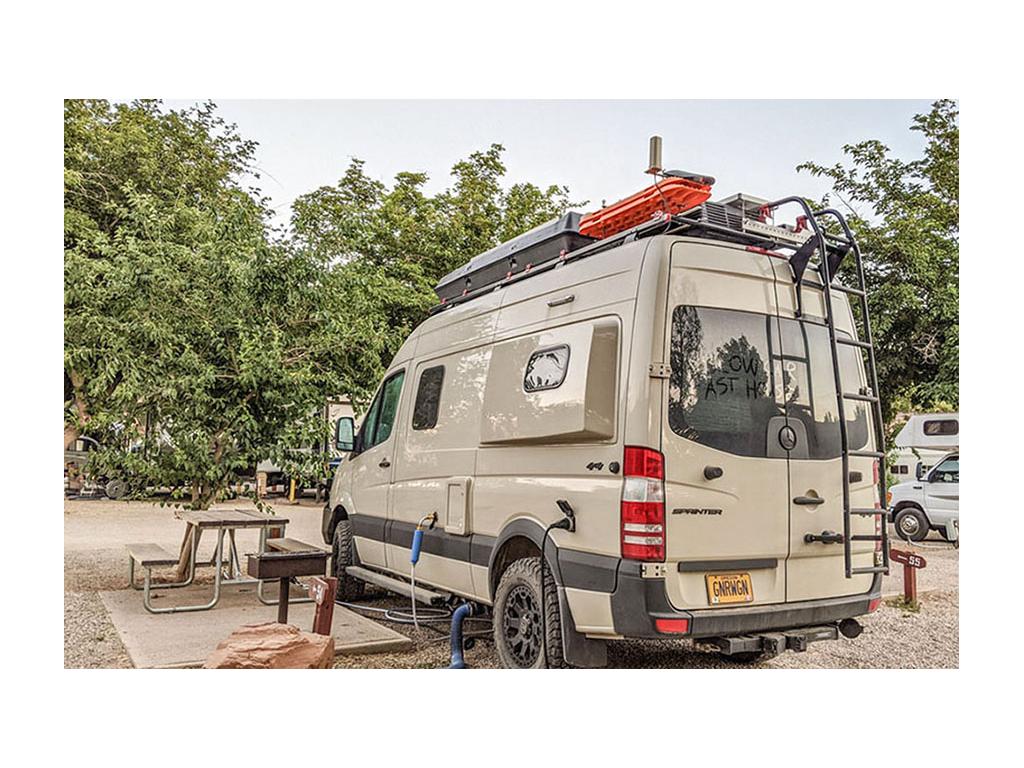 Revel parked at campsite hooked up to water and electric