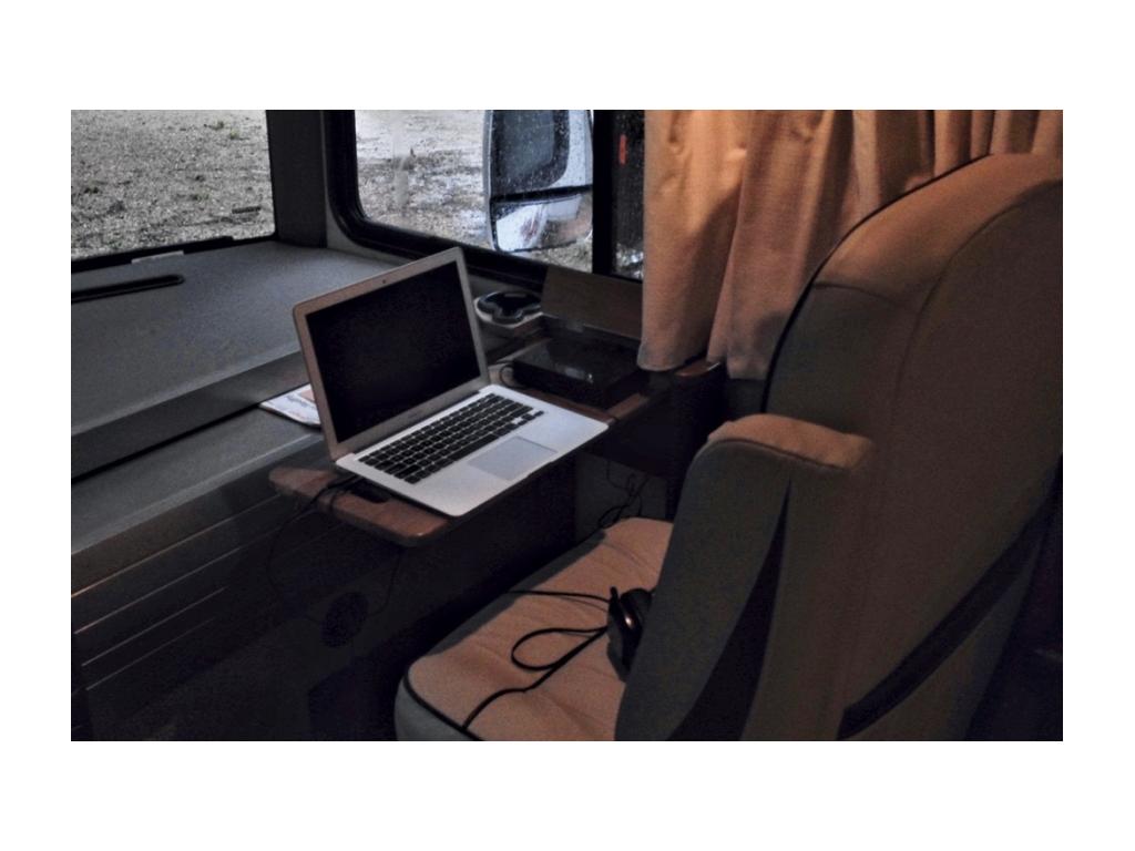 Tray with a laptop on it in front of the passenger seat.