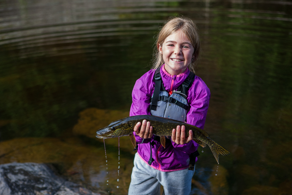 Girl holding a nice sized pike.