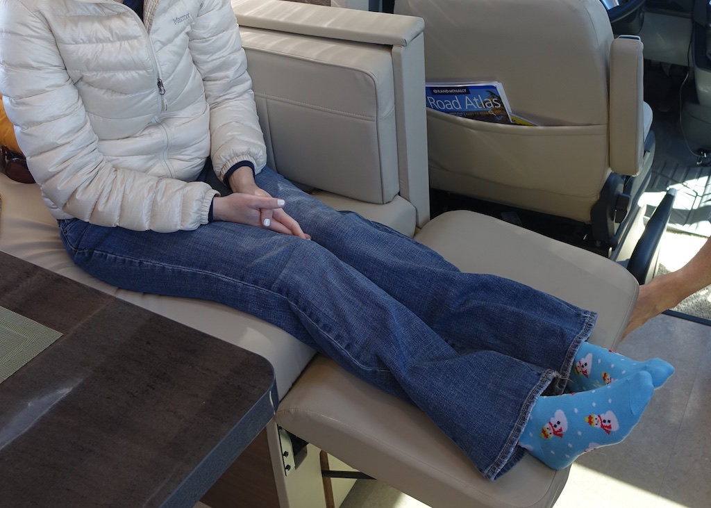 Woman sitting on chair with feet stretched out on footrest.