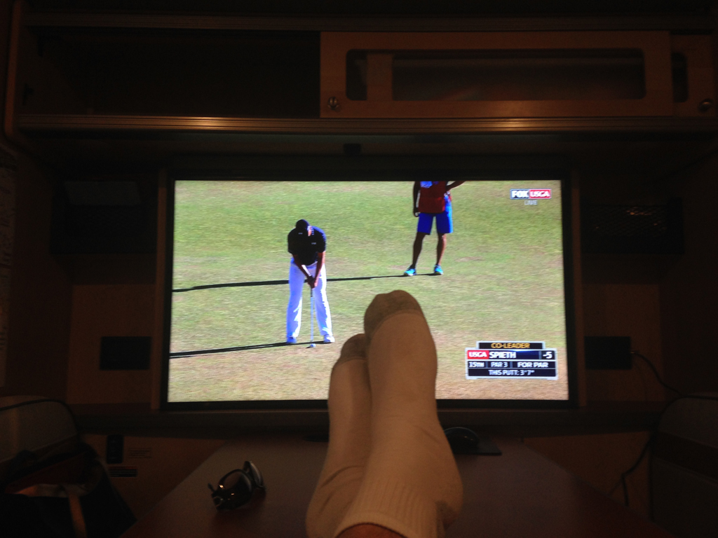 Person relaxing in front of the television with feet in the air.