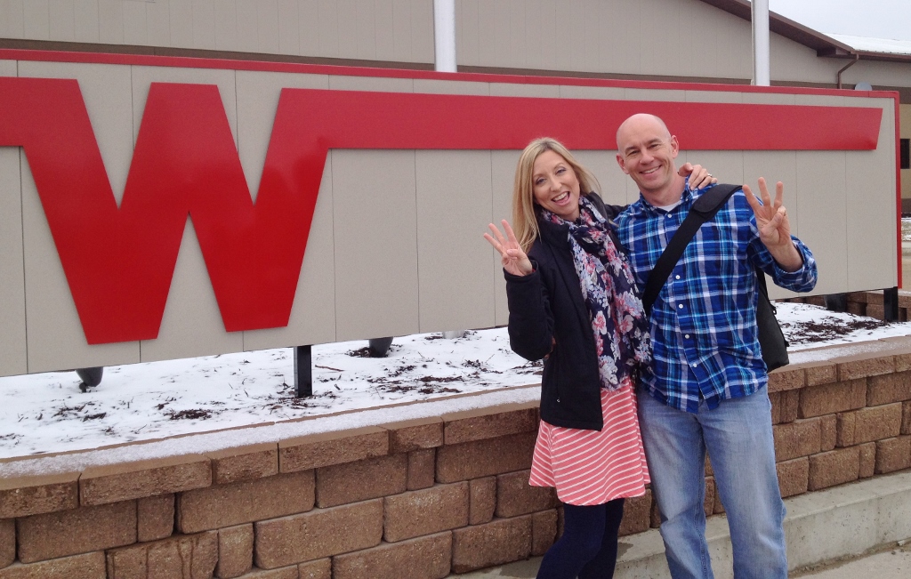 James and Stef standing in front of Winnebago sign.
