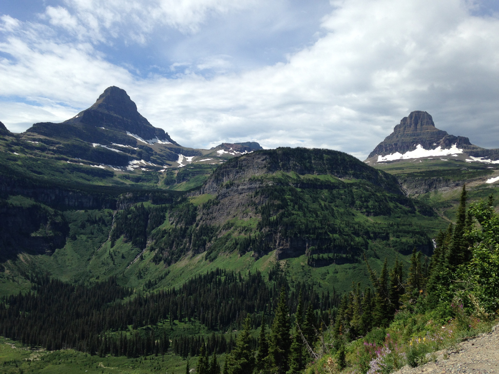 Rocky peaks among tree covered valley with trees.