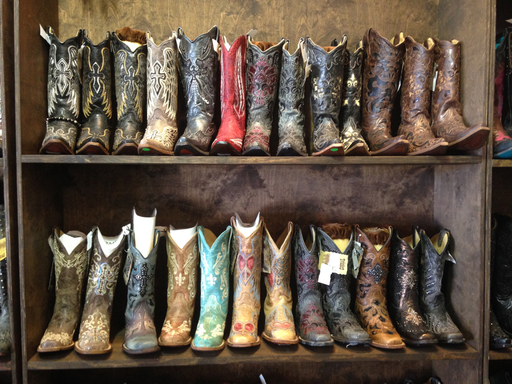 Two shelves full of cowboy boots.