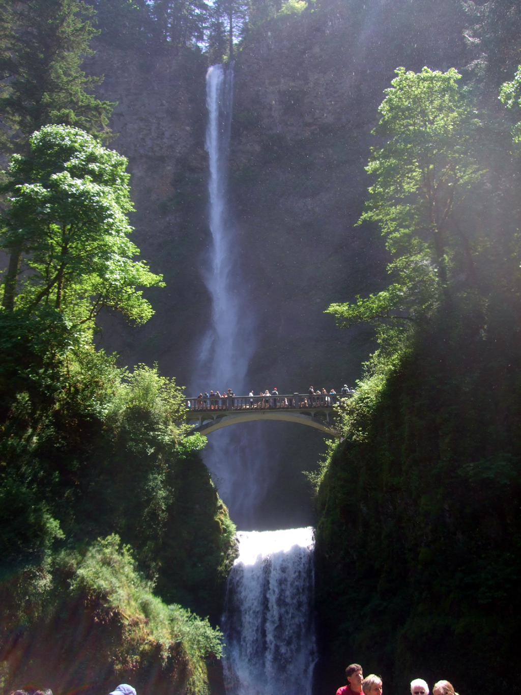 People gathered on bridge looking at Multnomah Falls.