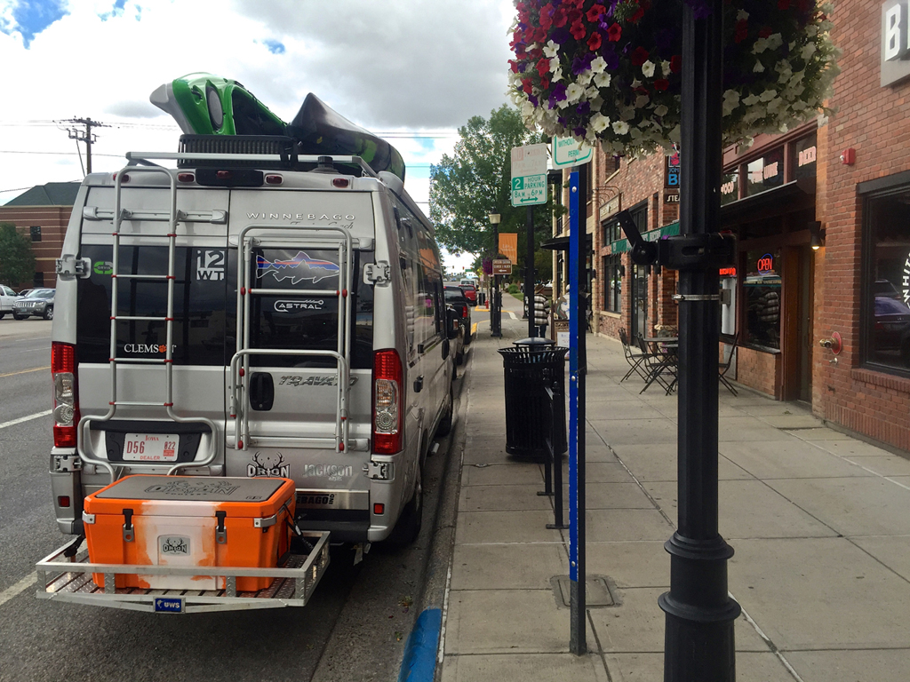 Winnebago Travato parked on street of a quaint downtown.