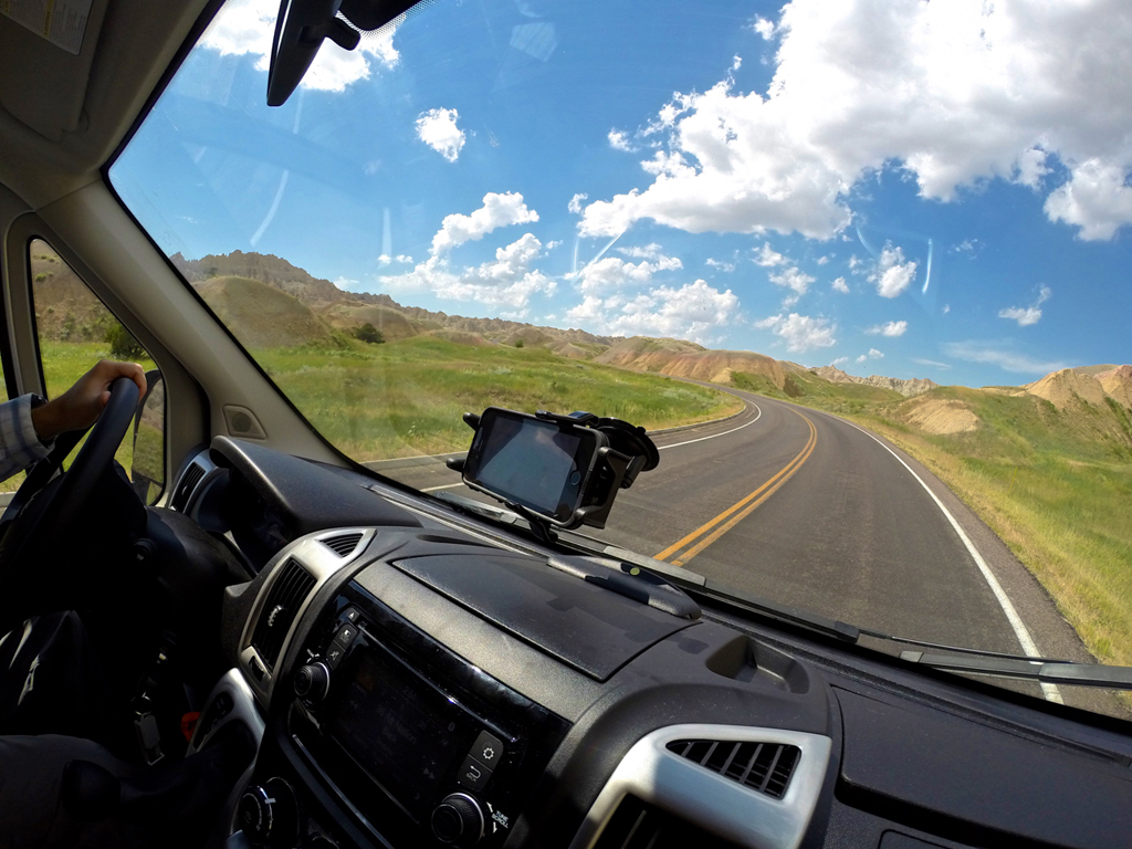 Driving down a highway towards mountains.