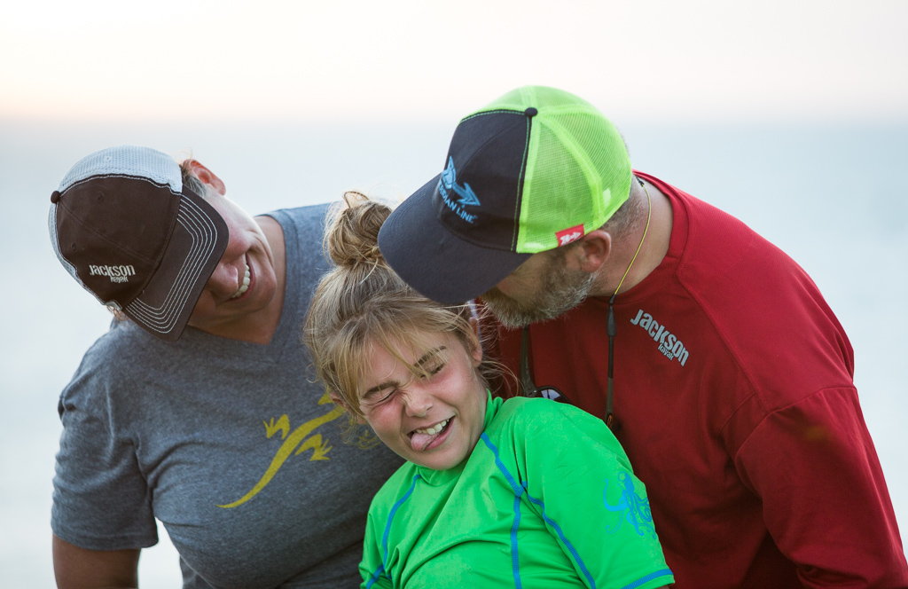 Family making faces and smiling at one another.