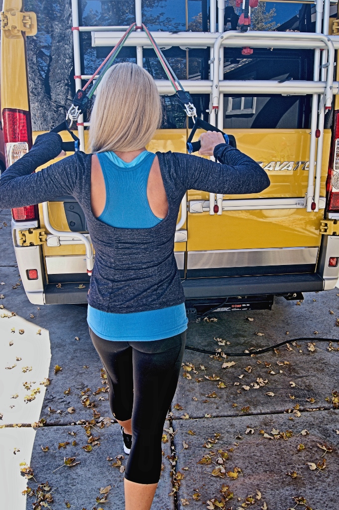 Stef working out with gear attached to the back of Winnebago Travato.