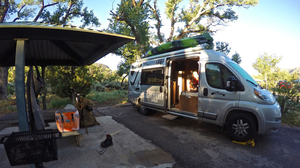 Winnebago Travato parked in campsite.