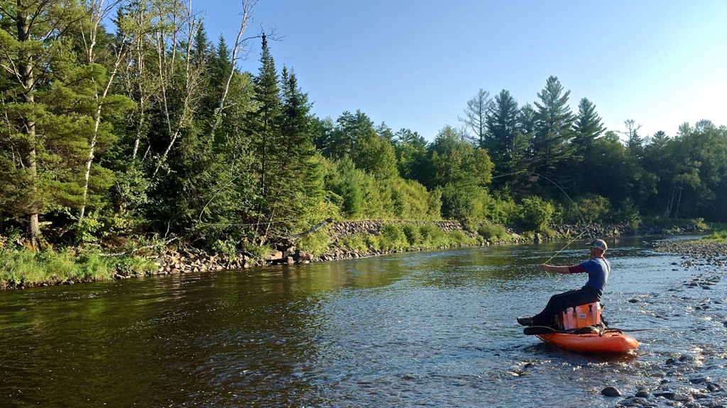 Man fly fishing from kayak.