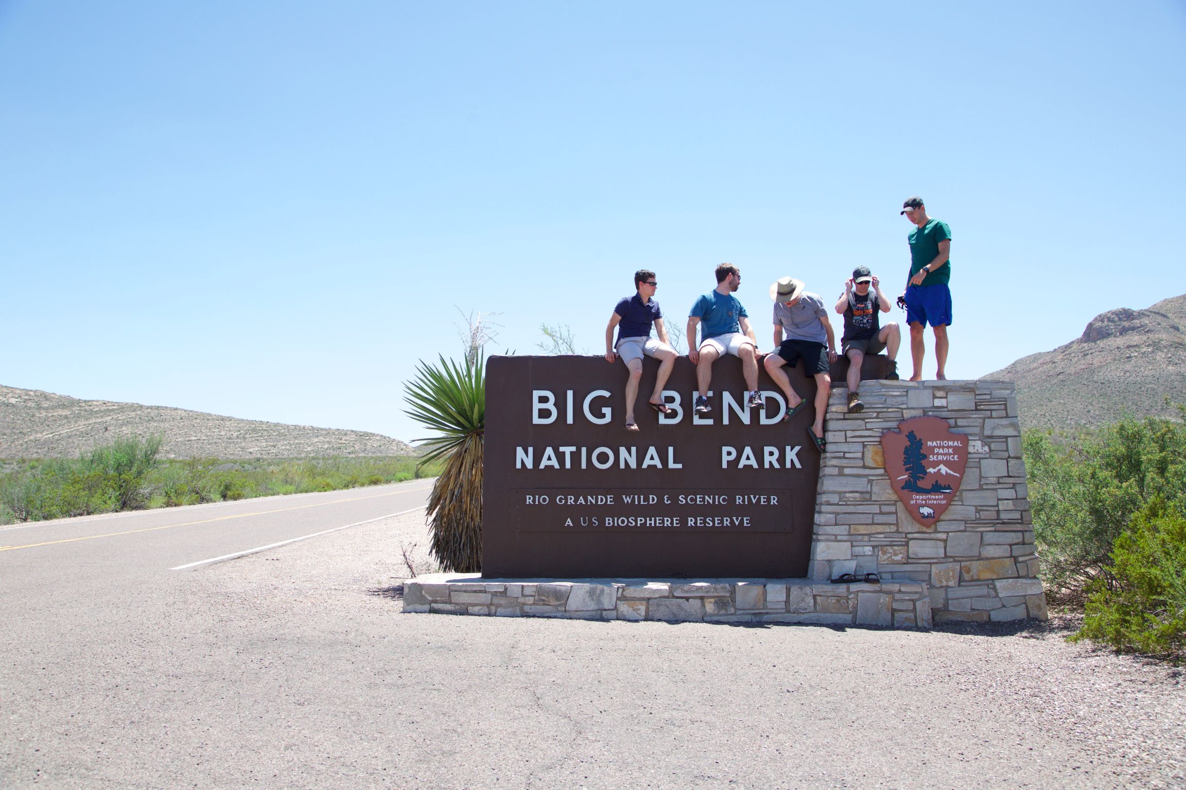 Group of five sitting atop the Big Bend National Park sign.