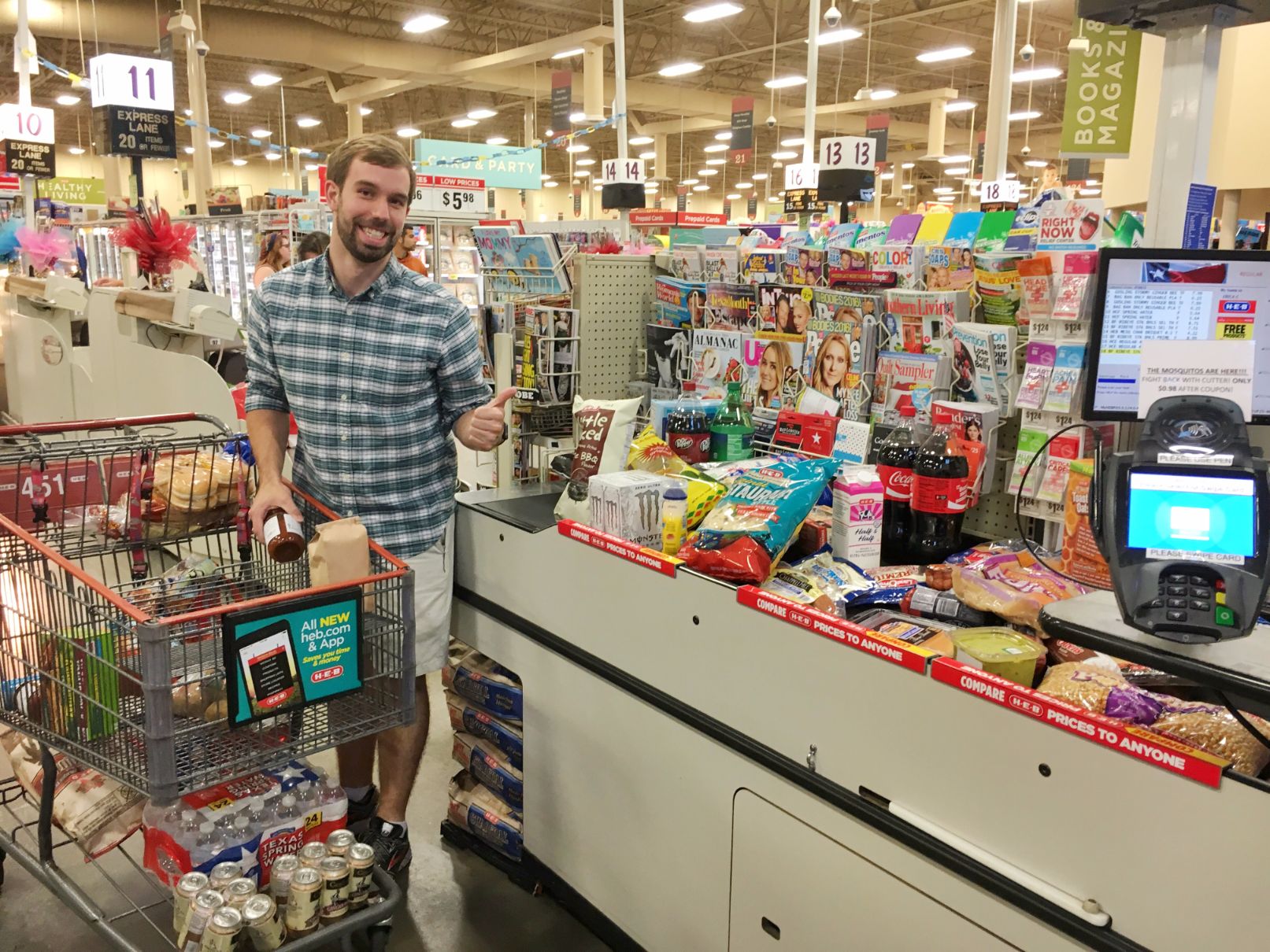 Man smiling at the check out line of a grocery store.