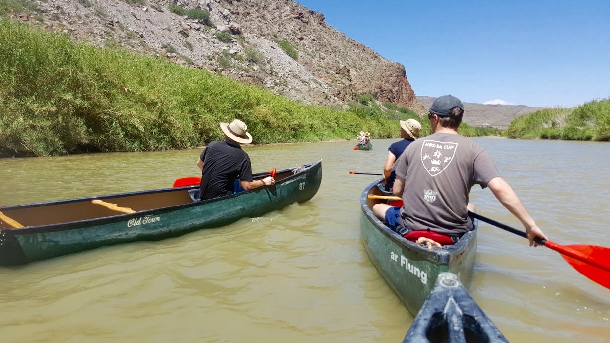 People in canoes on the river.