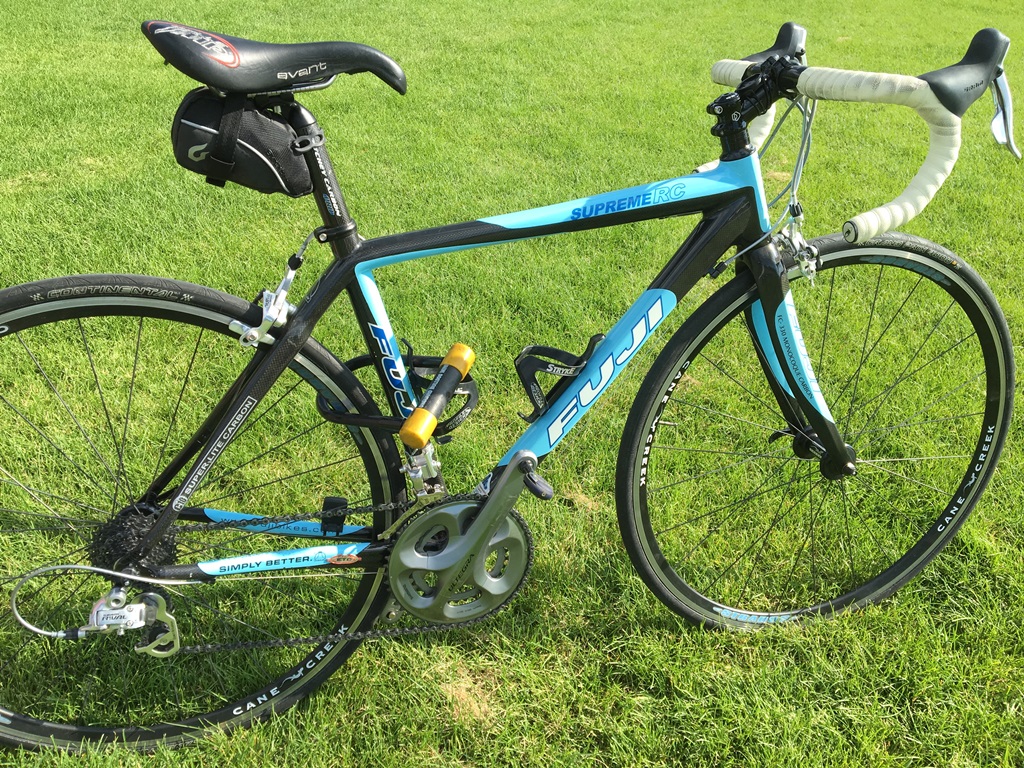 Immobilized bike sitting in the grass.