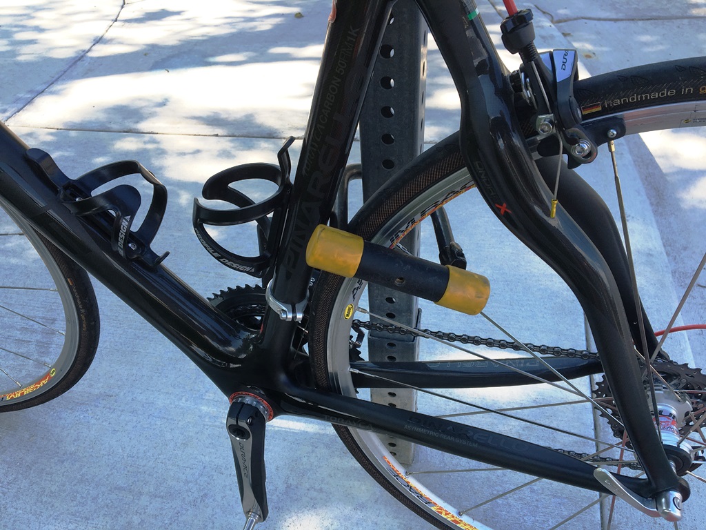 Bike attached to sign post with a lock.