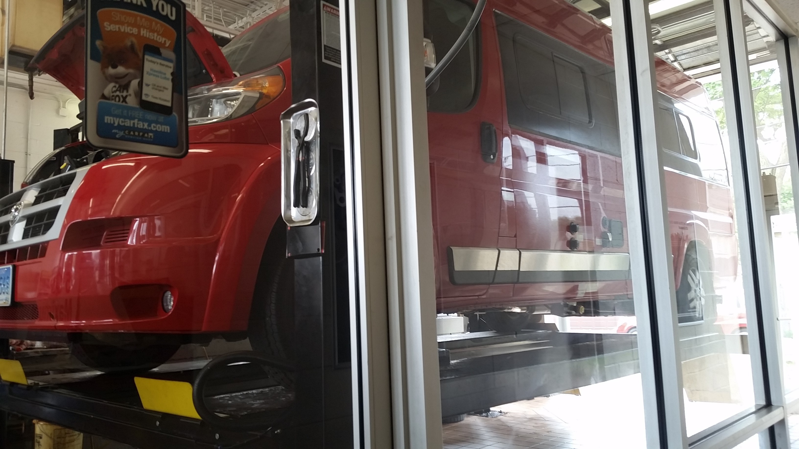Winnebago Travato on a lift at a garage.