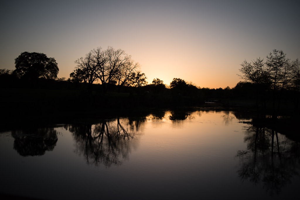 Setting sun over still pond.