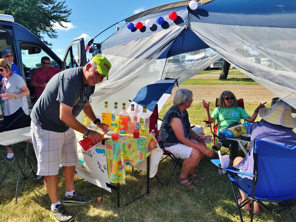 People gathered under a tent for happy hour.