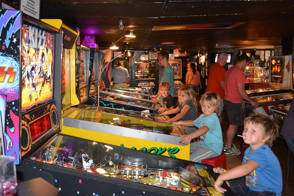 Kids sitting at old arcade games.